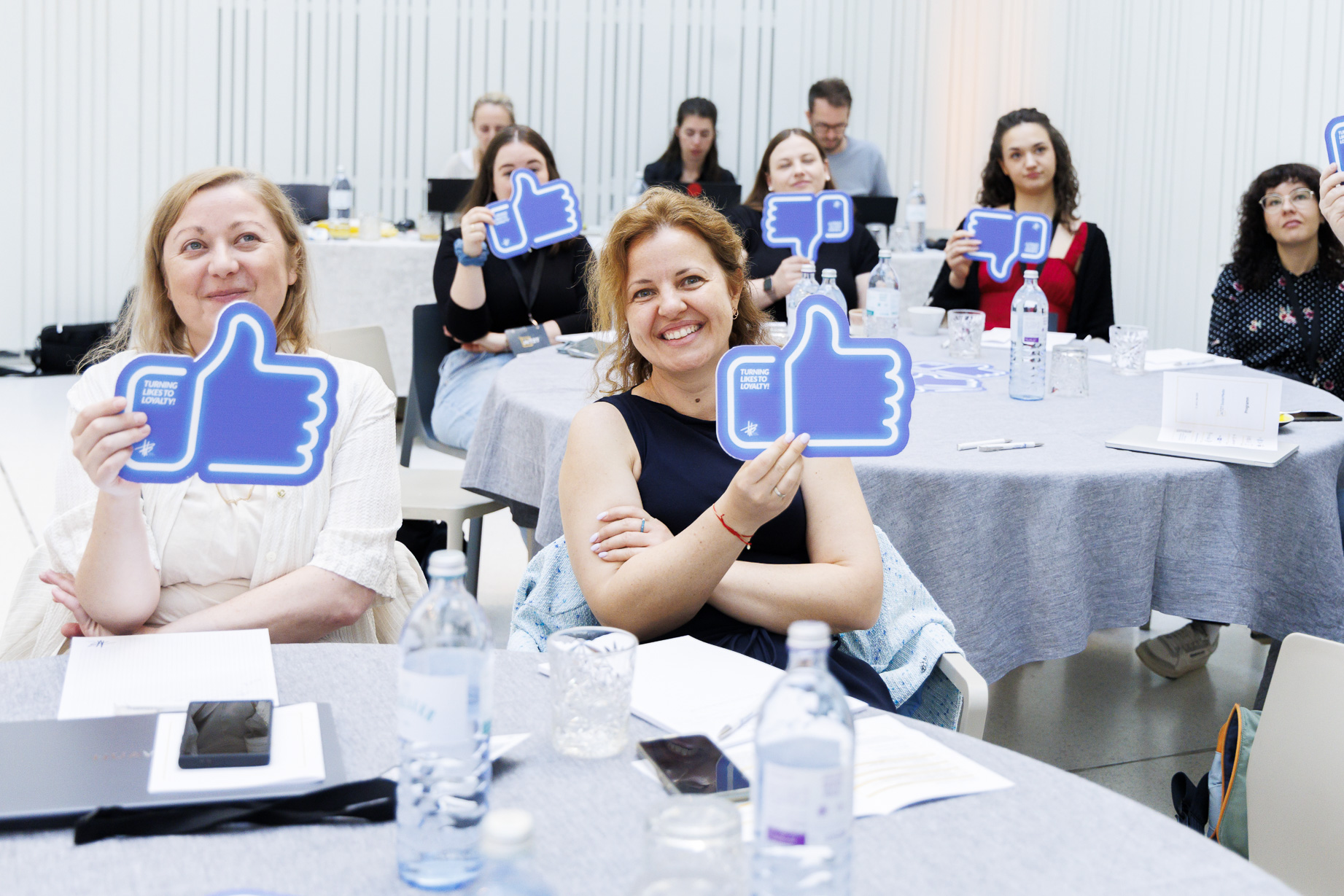 Teilnehmerinnen eines MediaBrothers Workshops halten Like-Schilder in die Höhe