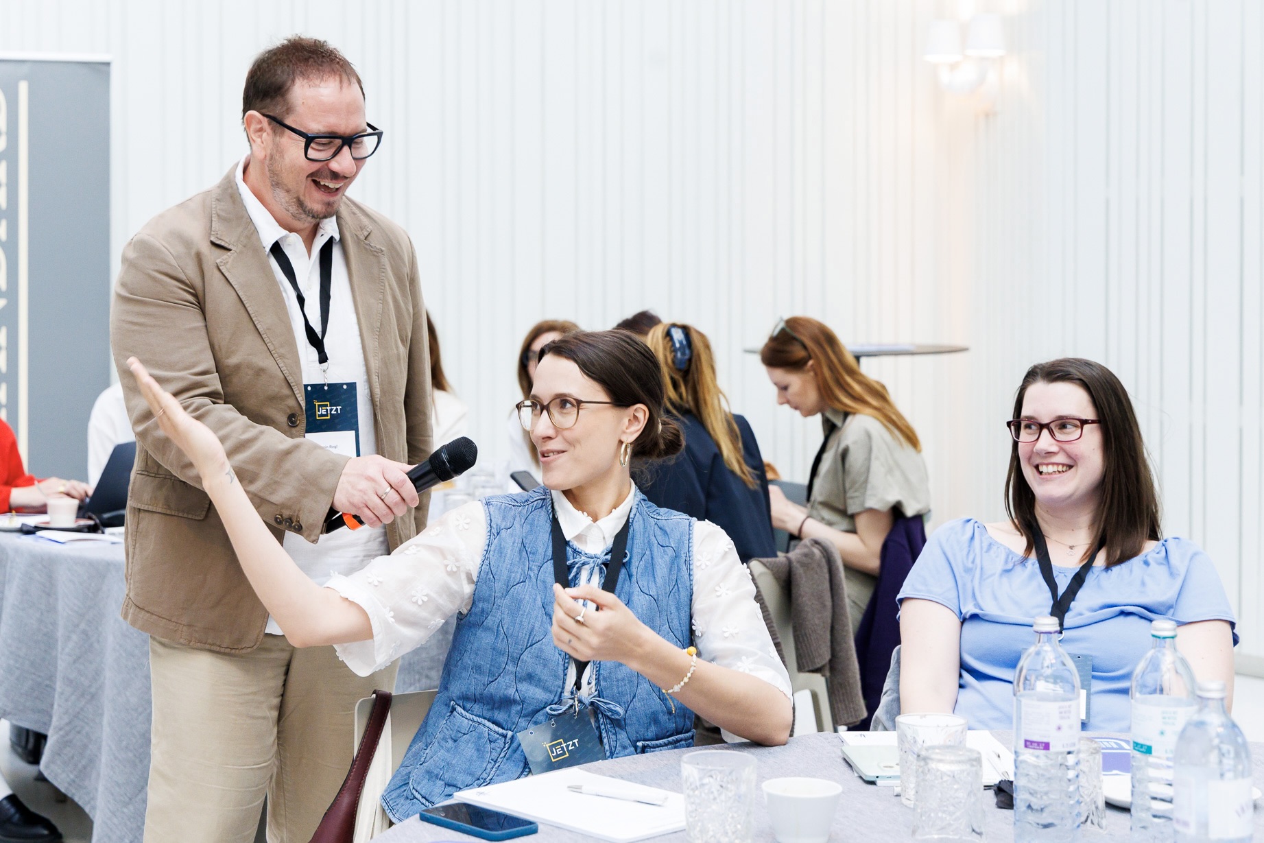 Armin Rogl im Dialog mit einer Workshop-Teilnehmerin mit Mikrofon